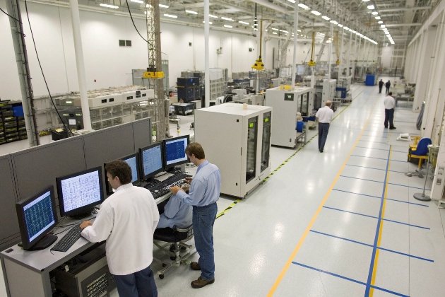 Workers overseeing industrial tech monitors in testing lab