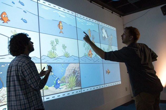 Game Animation Storyboard Collaborators presenting animated fish game storyboard on wall