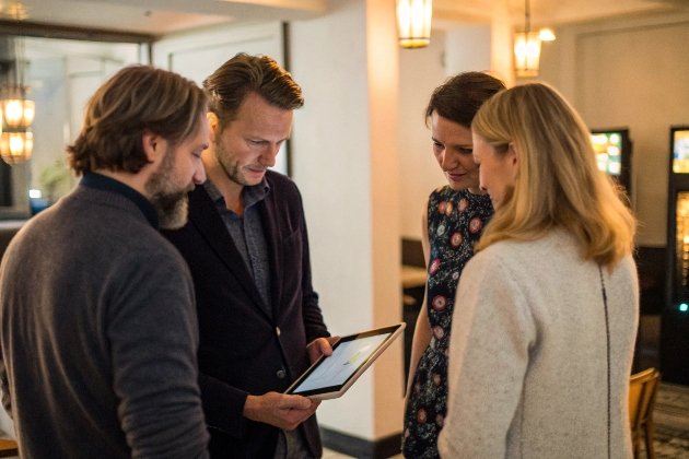 Professionals collaborating on tablet in gaming lounge setting