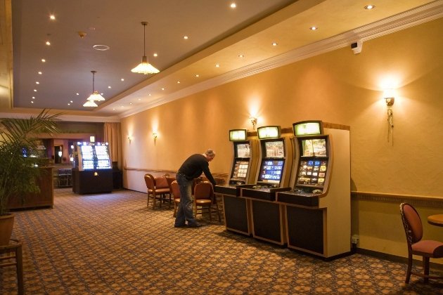 Slot Machine Maintenance Man cleaning slot machines in elegant gaming room