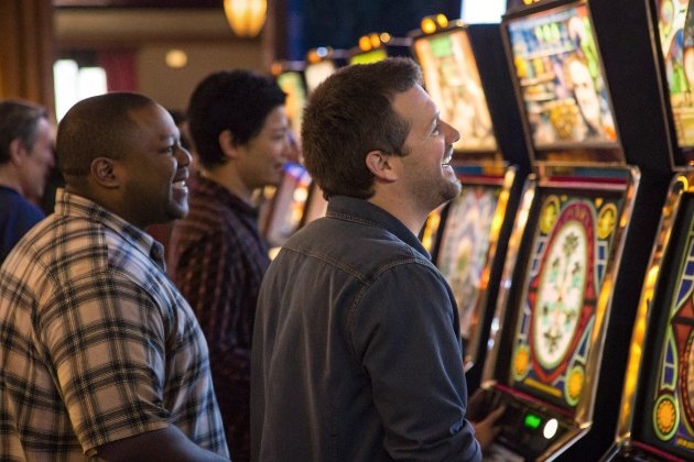 Group of friends joyfully playing colorful slot machines